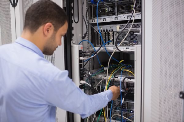 Man adjusting servers in data center